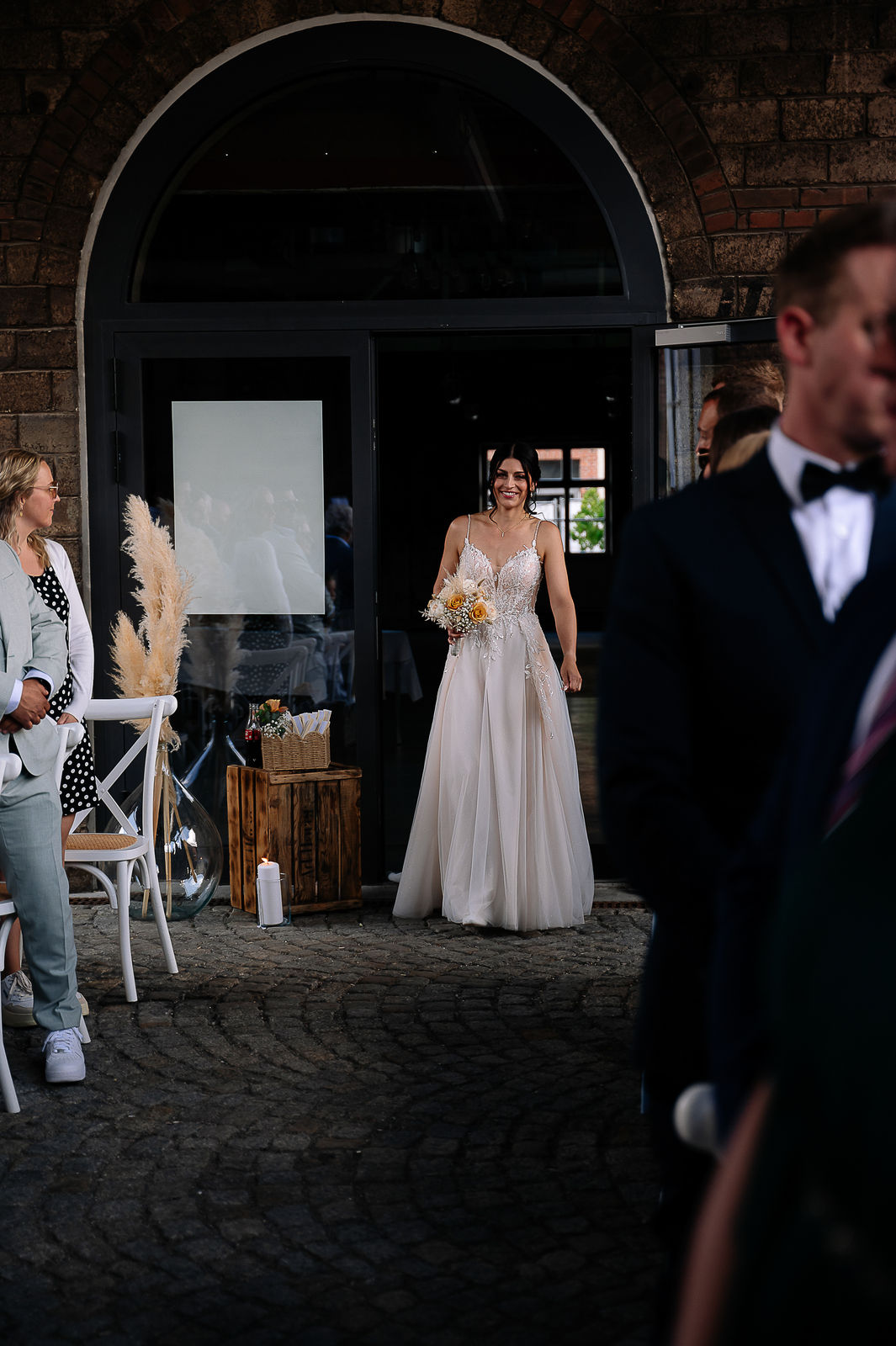 Brautpaar Sara und Olli bei ihrer Hochzeit in der Motorworld Village Metzingen vor historischer Backsteinkulisse.