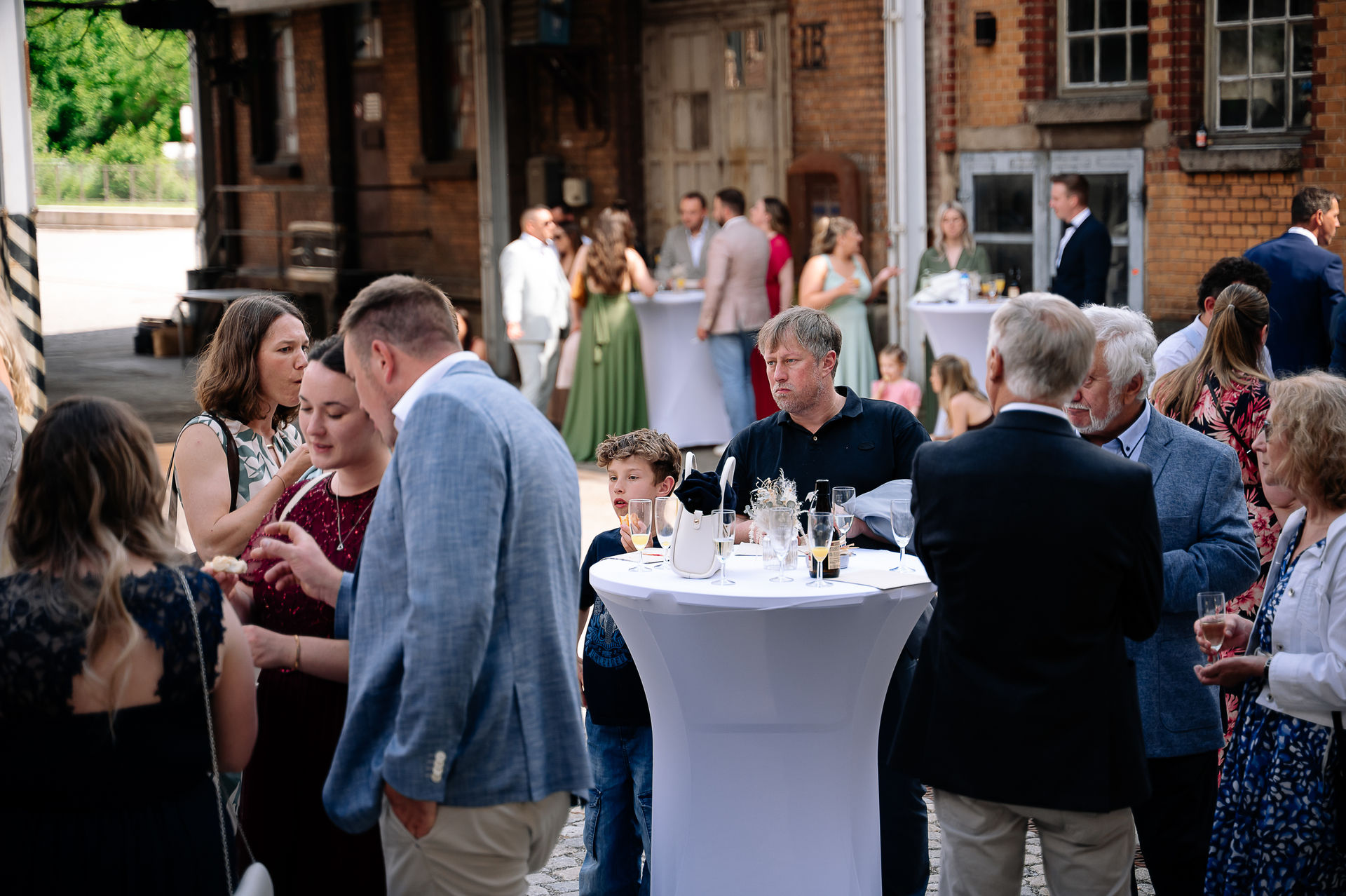 Brautpaar Sara und Olli bei ihrer Hochzeit in der Motorworld Village Metzingen vor historischer Backsteinkulisse.