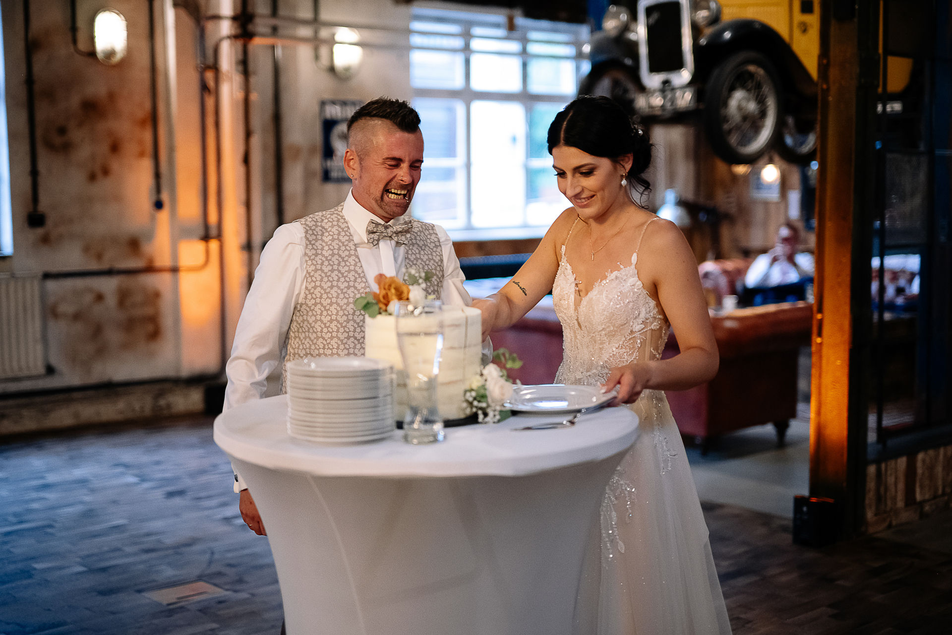 Brautpaar Sara und Olli bei ihrer Hochzeit in der Motorworld Village Metzingen vor historischer Backsteinkulisse.