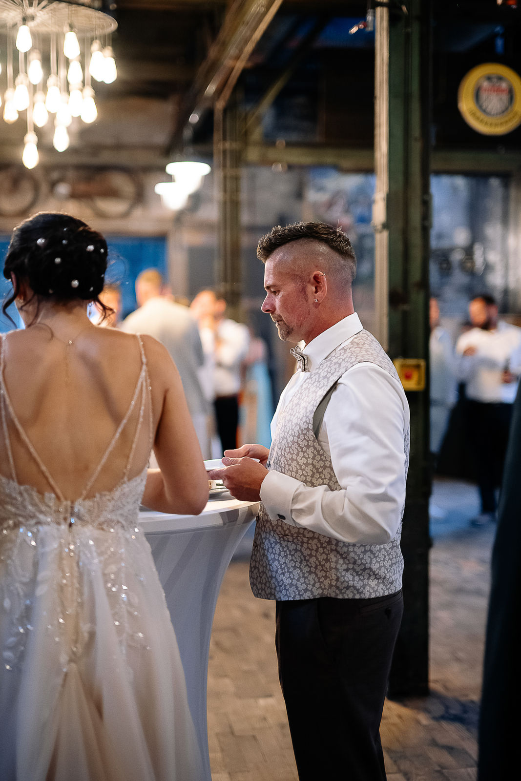 Brautpaar Sara und Olli bei ihrer Hochzeit in der Motorworld Village Metzingen vor historischer Backsteinkulisse.