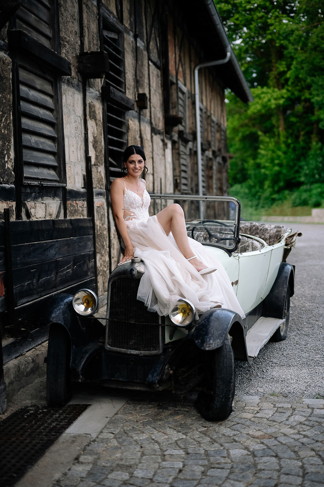 Brautpaar Sara und Olli bei ihrer Hochzeit in der Motorworld Village Metzingen vor historischer Backsteinkulisse.