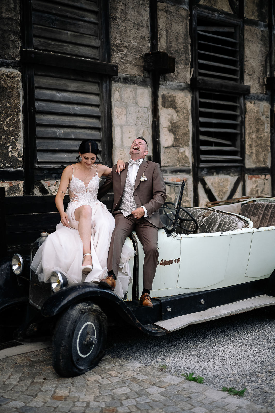 Brautpaar Sara und Olli bei ihrer Hochzeit in der Motorworld Village Metzingen vor historischer Backsteinkulisse.