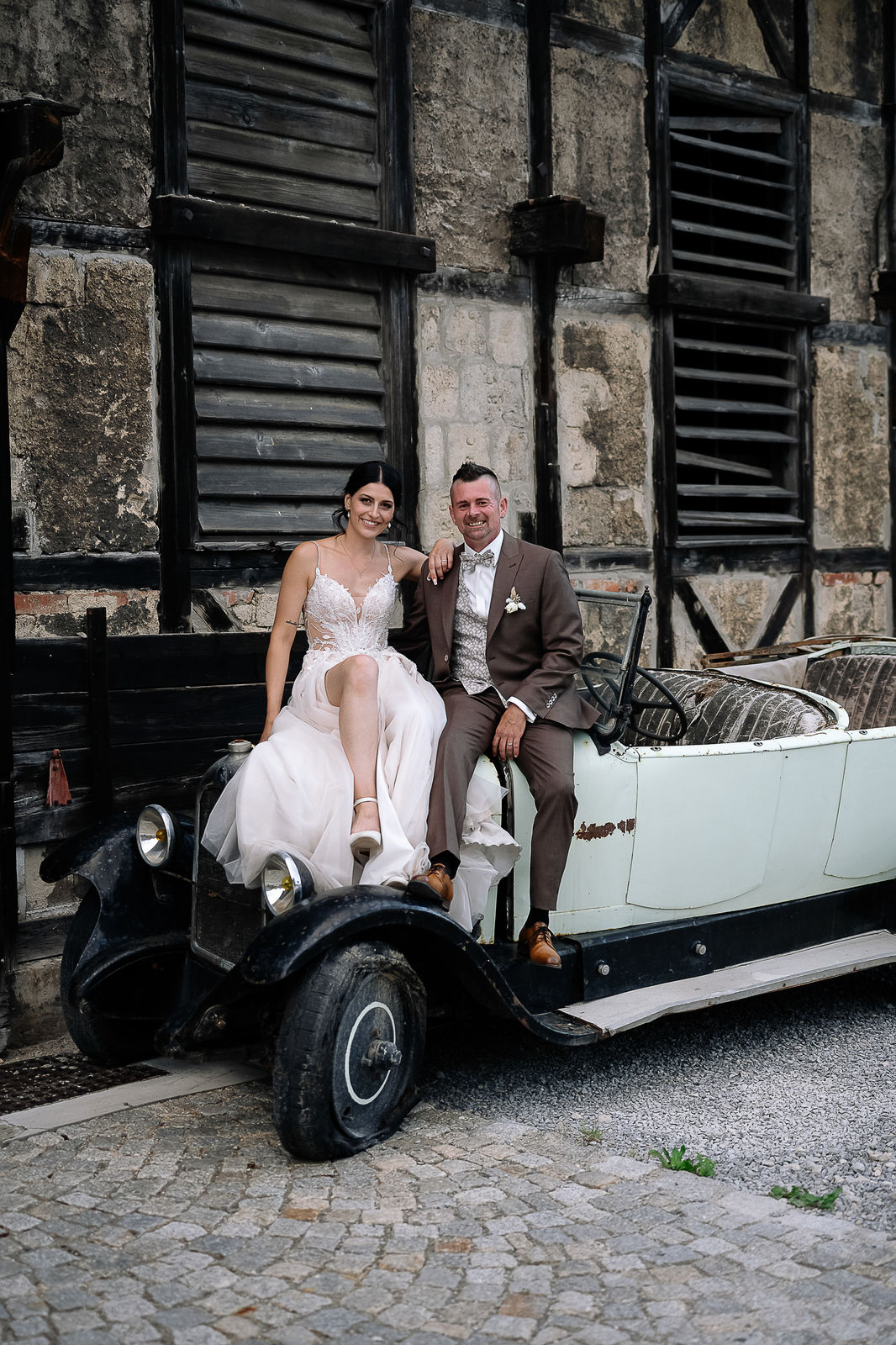 Brautpaar Sara und Olli bei ihrer Hochzeit in der Motorworld Village Metzingen vor historischer Backsteinkulisse.