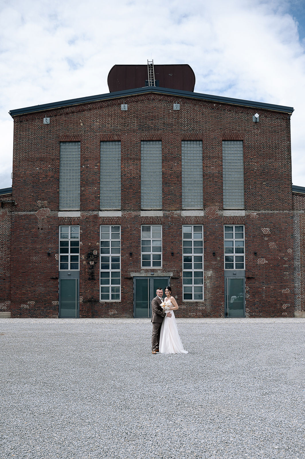 Romantisches Brautpaarshooting von Sara und Olli in der Motorworld Village Metzingen. Die einzigartige Kombination aus historischem Industriecharme und moderner Architektur schafft eine außergewöhnliche Kulisse für emotionale Hochzeitsfotos. Fotografiert von Nina Sander Photografie.